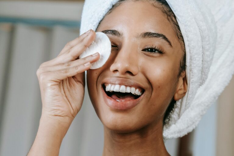 Person with their hair wrapped in a white towel practices a skin cycling routine