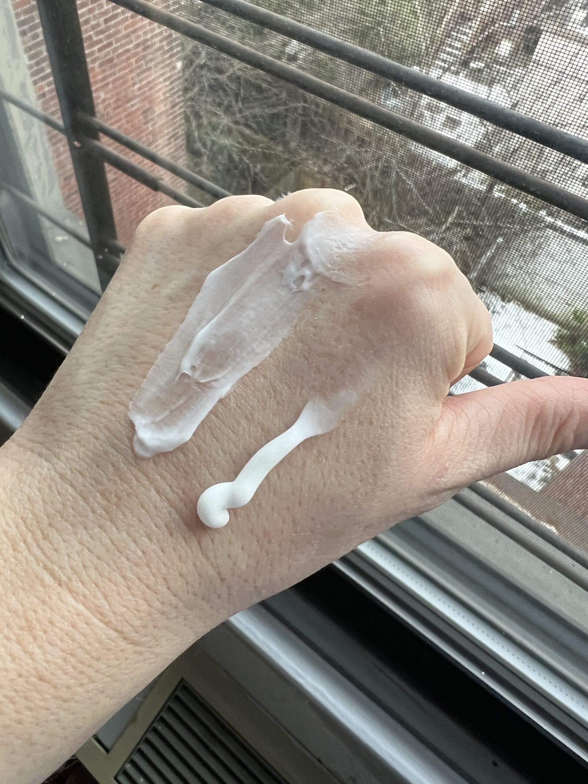 Someone with Nécessaire The Body Lotion on their hand