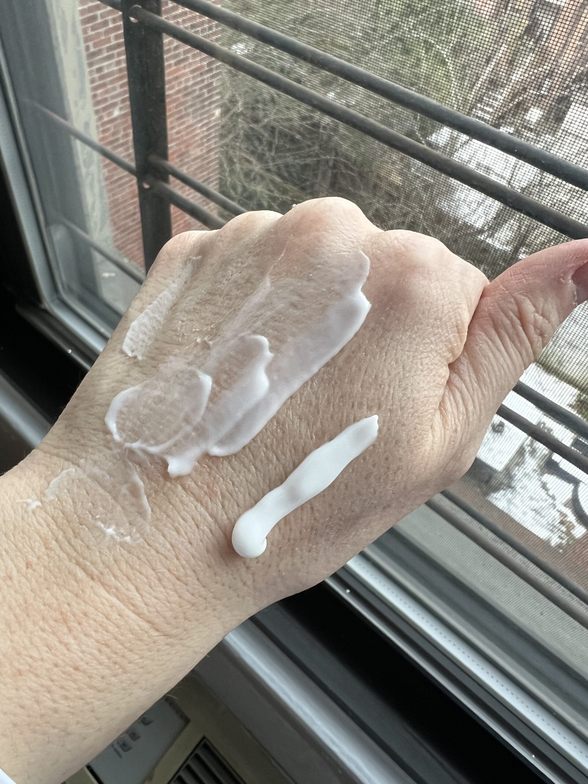 The Honest Company cream on someone's hand