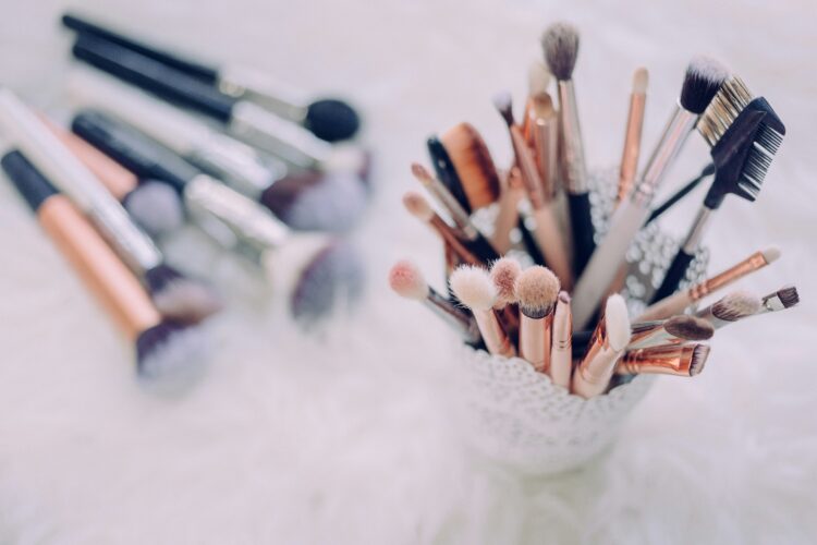 makeup brushes An aerial shot of makeup brushes laying flat with other brushes in a cup